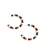 Paparazzi Accessories - Rural Retrograde - Multi Earrings earthy black, white, and Adobe stone beads are threaded along a dainty wire hoop, resulting in an earthy flair. Earring attaches to a standard post fitting. Hoop measures approximately 2" in diameter.  Sold as one pair of hoop earrings.