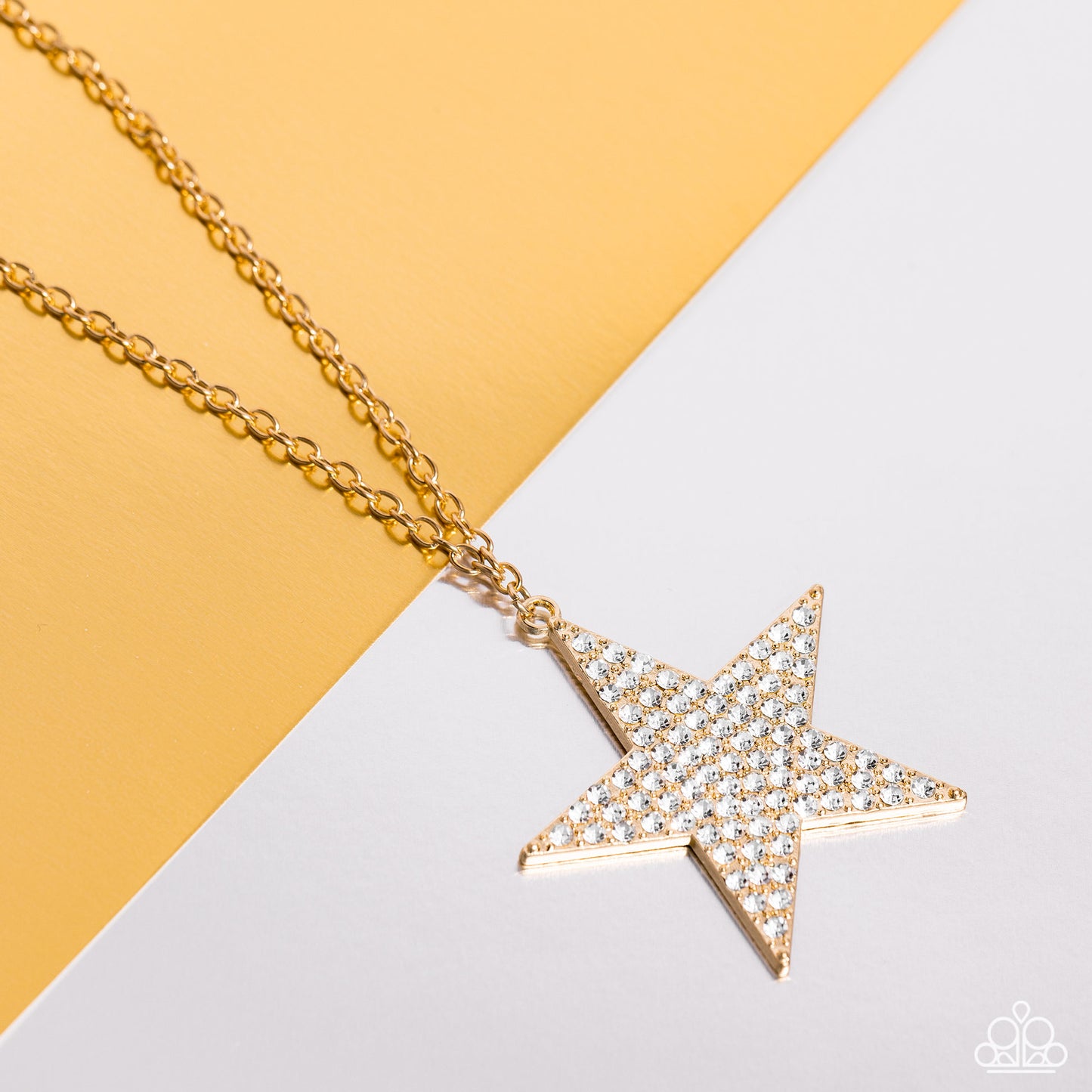 Paparazzi Accessories - Rock Star Sparkle Gold Necklaces a front of an oversized gold star is encrusted in blinding white rhinestones, resulting in a stellar pendant at the bottom of a lengthened gold chain. Features an adjustable clasp closure.  Sold as one individual necklace. Includes one pair of matching earrings.
