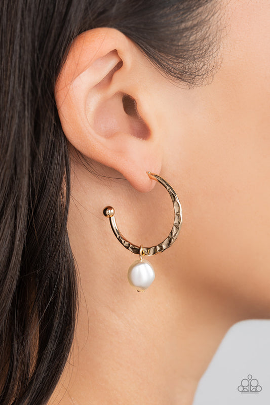 Paparazzi Accessories - Glam Overboard - Gold Hoop Earrings an imperfect white pearl glides along a hammered gold hoop, creating a timeless twist. Earring attaches to a standard post fitting. Hoop measures approximately 1" in diameter.  Sold as one pair of hoop earrings.