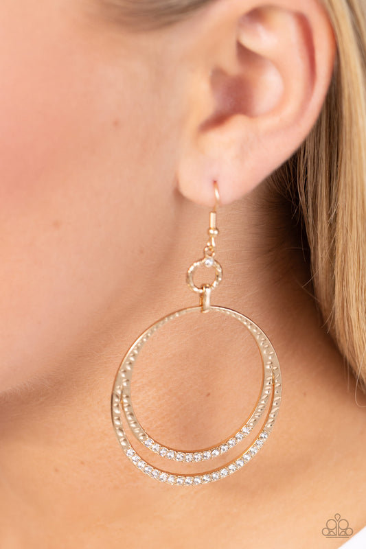 Paparazzi Accessories - Spin Your HEELS - Gold Earrings dainty white rhinestones sparkle along the bottoms of a hammered gold hoop that splits into glistening layers, creating a glamorous effect. Earring attaches to a standard fishhook fitting.  Sold as one pair of earrings.
