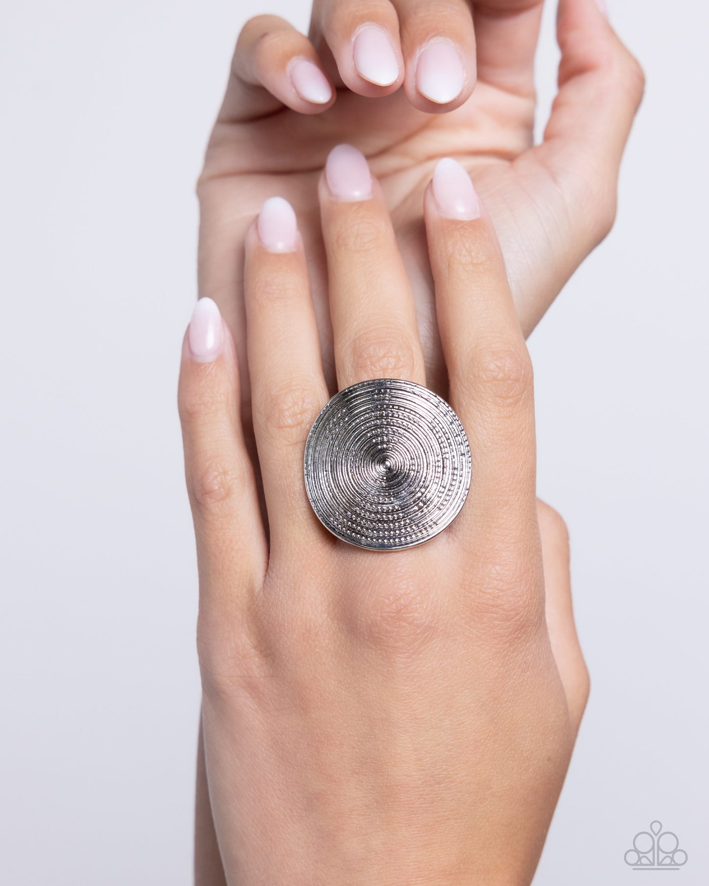 Featuring an understated dot motif, shimmery textured circles radiate into an oversized, dizzying, concaved silver frame atop the finger. Features a stretchy band for a flexible fit. Sold as one individual ring.