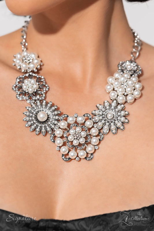 Polished white pearls and brilliant white rhinestones bloom atop a framework of silver, forming seven unique flowers adorned in dizzying detail. Each flower features a unique centerpiece encircled by silver petals lined with luminescence and intricate detail. The flourish of florals links whimsically along the neckline, resulting in an unforgettable statement piece that sparkles with sentiment. Features an adjustable clasp closure.  Sold as one individual necklace. Includes one pair of matching earrings.