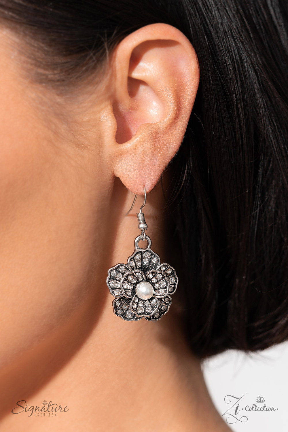Polished white pearls and brilliant white rhinestones bloom atop a framework of silver, forming seven unique flowers adorned in dizzying detail. Each flower features a unique centerpiece encircled by silver petals lined with luminescence and intricate detail. The flourish of florals links whimsically along the neckline, resulting in an unforgettable statement piece that sparkles with sentiment. Features an adjustable clasp closure. Sold as one individual necklace. Includes one pair of matching earrings.