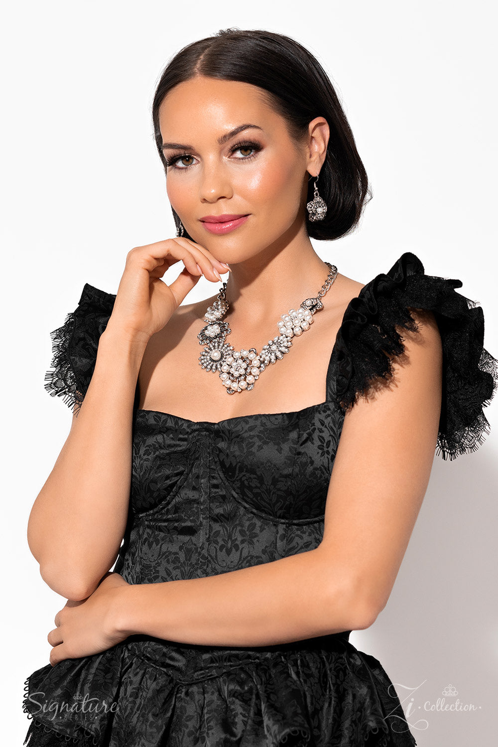 Polished white pearls and brilliant white rhinestones bloom atop a framework of silver, forming seven unique flowers adorned in dizzying detail. Each flower features a unique centerpiece encircled by silver petals lined with luminescence and intricate detail. The flourish of florals links whimsically along the neckline, resulting in an unforgettable statement piece that sparkles with sentiment. Features an adjustable clasp closure. Sold as one individual necklace. Includes one pair of matching earrings.