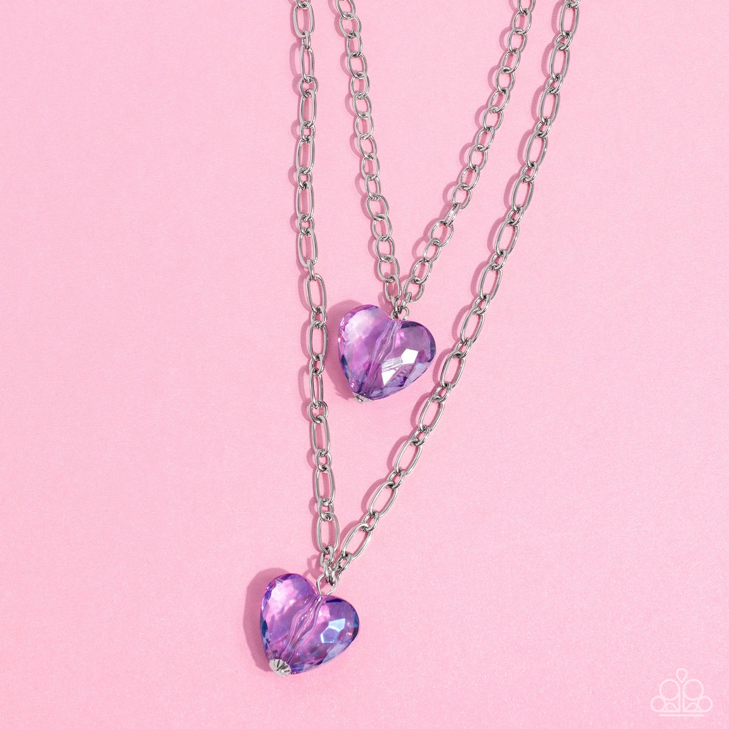 Paparazzi Accessories - Layered Love - Purple Heart Necklaces featuring a subtle iridescent shimmer, two glassy purple gem hearts are delicately suspended above one another on a paperclip and silver oval link chain for a whimsical double-stacked display. Features an adjustable clasp closure. Sold as one individual necklace. Includes one pair of matching earrings.