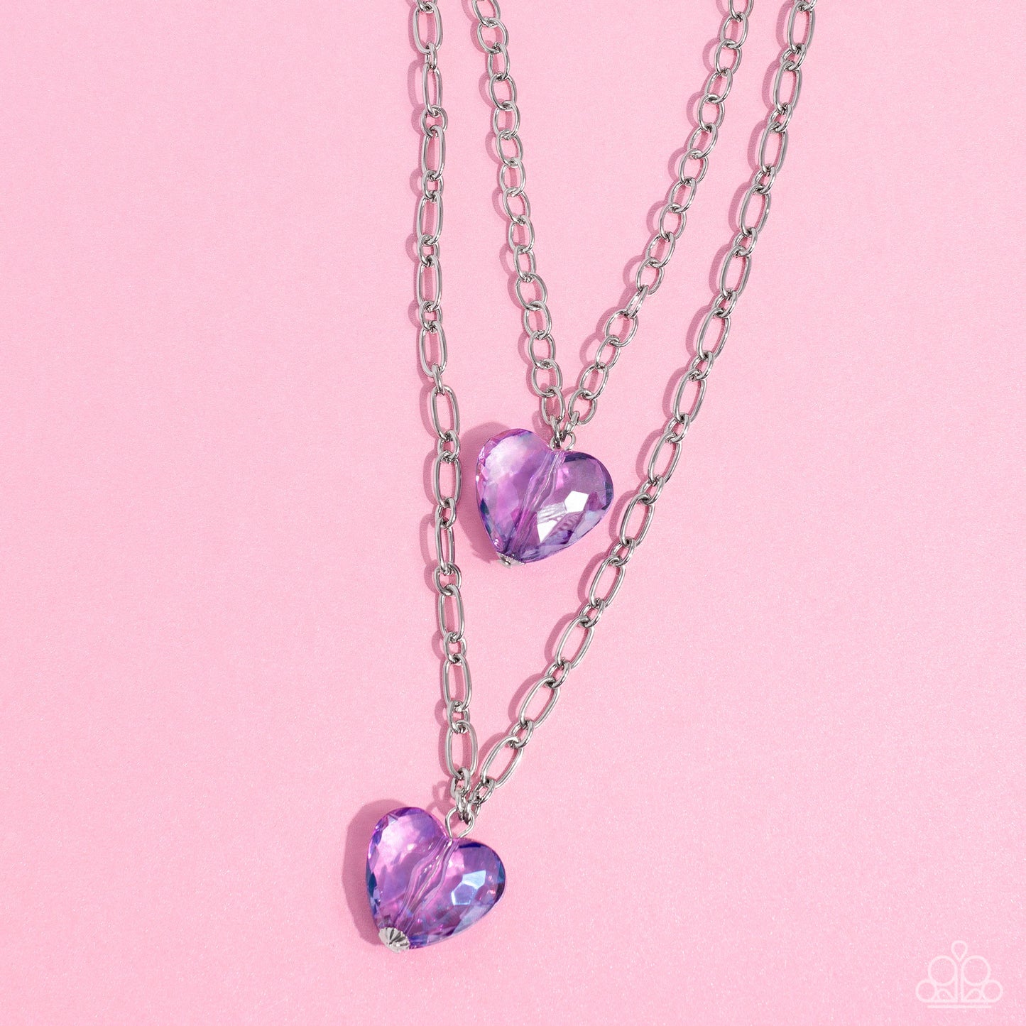 Paparazzi Accessories - Layered Love - Purple Heart Necklaces featuring a subtle iridescent shimmer, two glassy purple gem hearts are delicately suspended above one another on a paperclip and silver oval link chain for a whimsical double-stacked display. Features an adjustable clasp closure.  Sold as one individual necklace. Includes one pair of matching earrings.