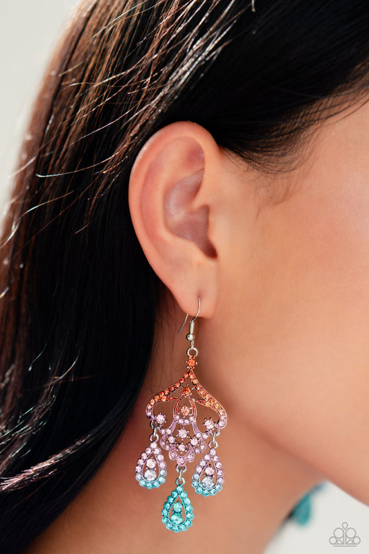 Paparazzi Accessories - Chandelier Command - Multi Earrings three rhinestone-encrusted teardrops drip from the bottom of an ornate decorative frame, creating an elegant fringe. The decorative frame swirls with ombré rhinestones that go from orange to pink to blue shades in varying sizes for a timelessly over-the-top sparkle. Earring attaches to a standard fishhook fitting.
Sold as one pair of earrings.