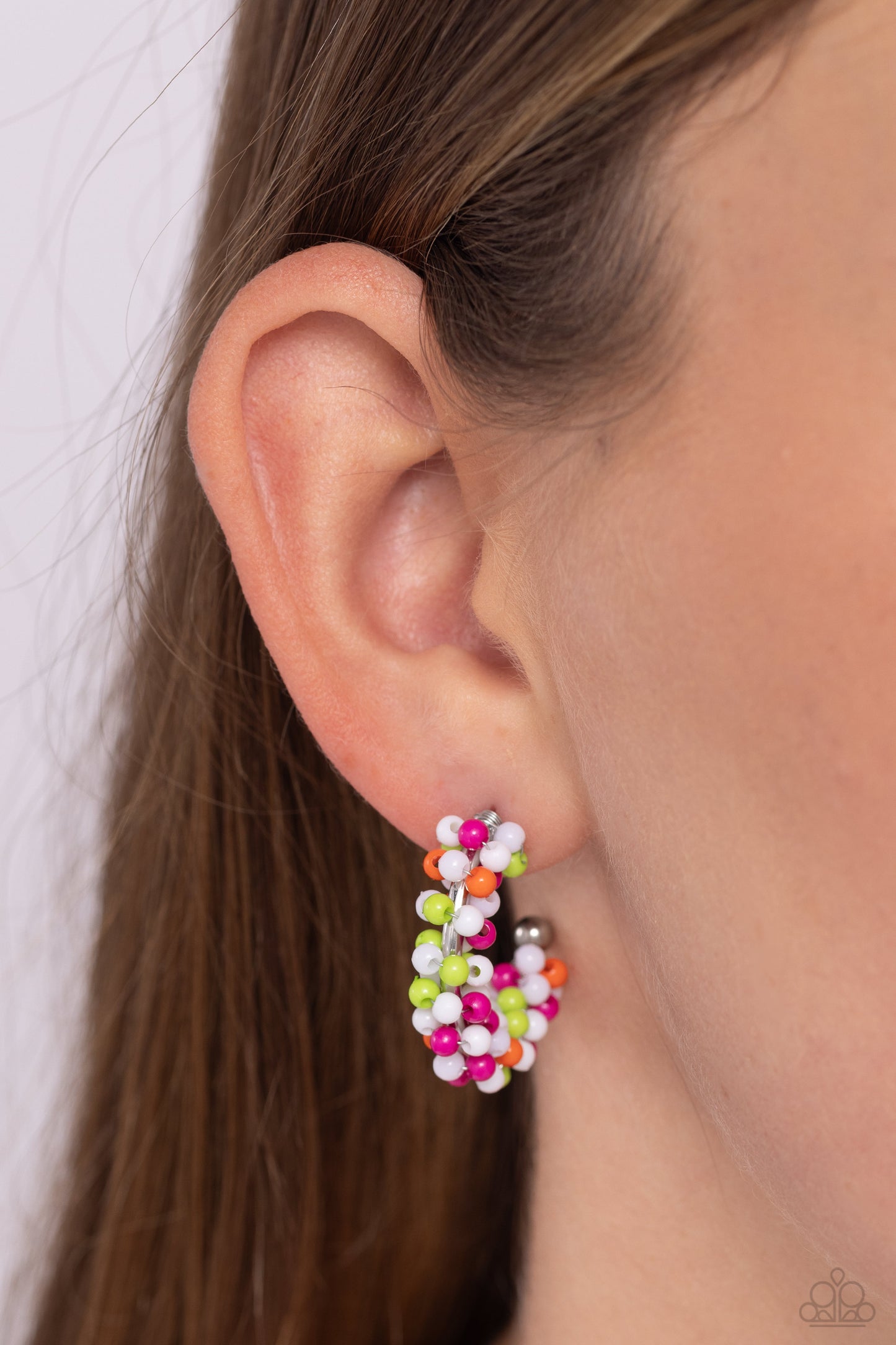 Paparazzi Accessories - Ballon Backdrop - White Hoop Earrings a colorful collection of white, Kohlrabi, Rose Violet, and orange seed beads are wrapped along the outside curve of a shiny, silver hoop by shimmery silver wire for a handcrafted, carefree finish. A shiny silver ball is affixed to the end of the hoop, reminiscent of a barbell fitting. Earring attaches to a standard post fitting. Hoop measures approximately 1" in diameter. Sold as one pair of hoop earrings.