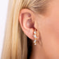 Paparazzi Accessories - Sliding Shimmer - Gold Earrings a glassy collection of white round, marquise-cut, and emerald-cut rhinestones and gems are pronged in place along a curved gold bar. Features a sleek surface for sliding ability to desired position on the ear. Due to its structure, adjusting capability is limited.  Sold as one pair of illusion post earrings.