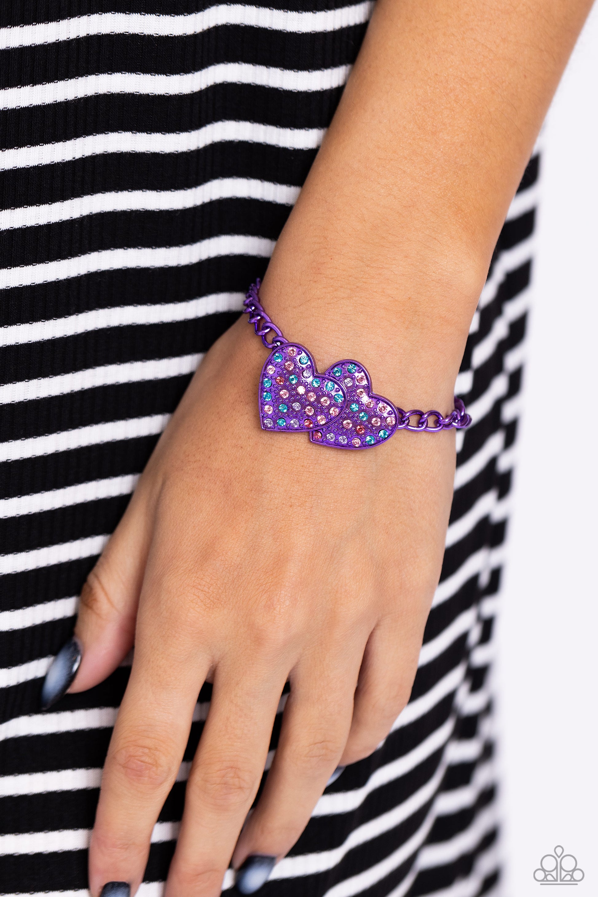 Paparazzi Accessories - Lowkey Lovestruck - Purple Jewelry Sets dipped in an electric purple hue, a strand of bulky chain gives way to three heart frames below the collar. Dotted with tactile electric purple studs, the interlocked heart frames feature various pink, blue, purple, and white rhinestones for a timeless finish. Features an adjustable clasp closure. Sold as one individual necklace. Includes one pair of matching earrings.