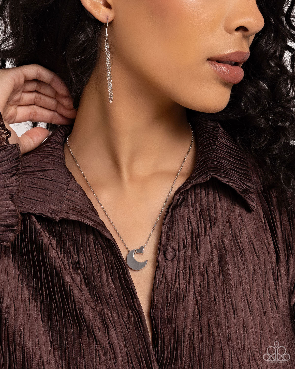 Infused along a dainty silver chain, a silver crescent moon and silver heart charm connect below the collar for a stellar statement. Features an adjustable clasp closure. Sold as one individual necklace. Includes one pair of matching earrings. Delicately cascading from a silver laurel chain, a chiseled oil spill dipped stone swings from the bottom of a shiny silver crescent-shaped hoop, creating a seasonal lure. Earring attaches to a standard fishhook fittings. Sold as one pair of earrings.