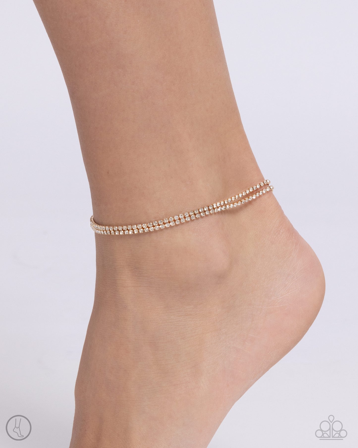 <div class="sku" data-v-510a33b4="">Paparazzi Accessories - Dainty Declaration - Gold Anklets s<span style="font-size: 1rem;">et in gold square fittings, two strands of white rhinestones coalesce around the ankle for a simply shimmering statement. Features an adjustable clasp closure.</span></div> <div class="description" data-v-510a33b4=""> <p><i>Sold as one individual anklet.</i></p> </div>