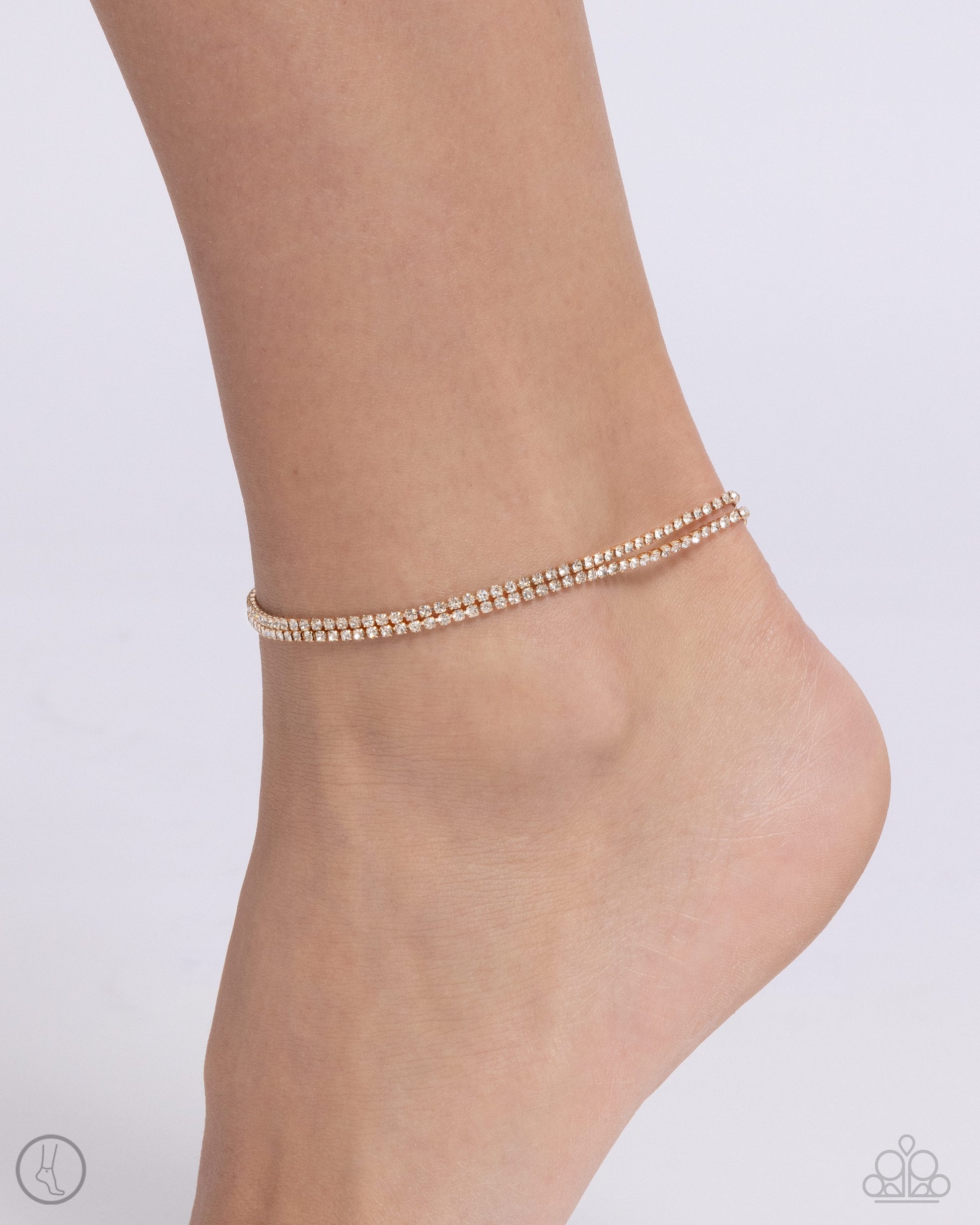 <div class="sku" data-v-510a33b4="">Paparazzi Accessories - Dainty Declaration - Gold Anklets s<span style="font-size: 1rem;">et in gold square fittings, two strands of white rhinestones coalesce around the ankle for a simply shimmering statement. Features an adjustable clasp closure.</span></div> <div class="description" data-v-510a33b4=""> <p><i>Sold as one individual anklet.</i></p> </div>