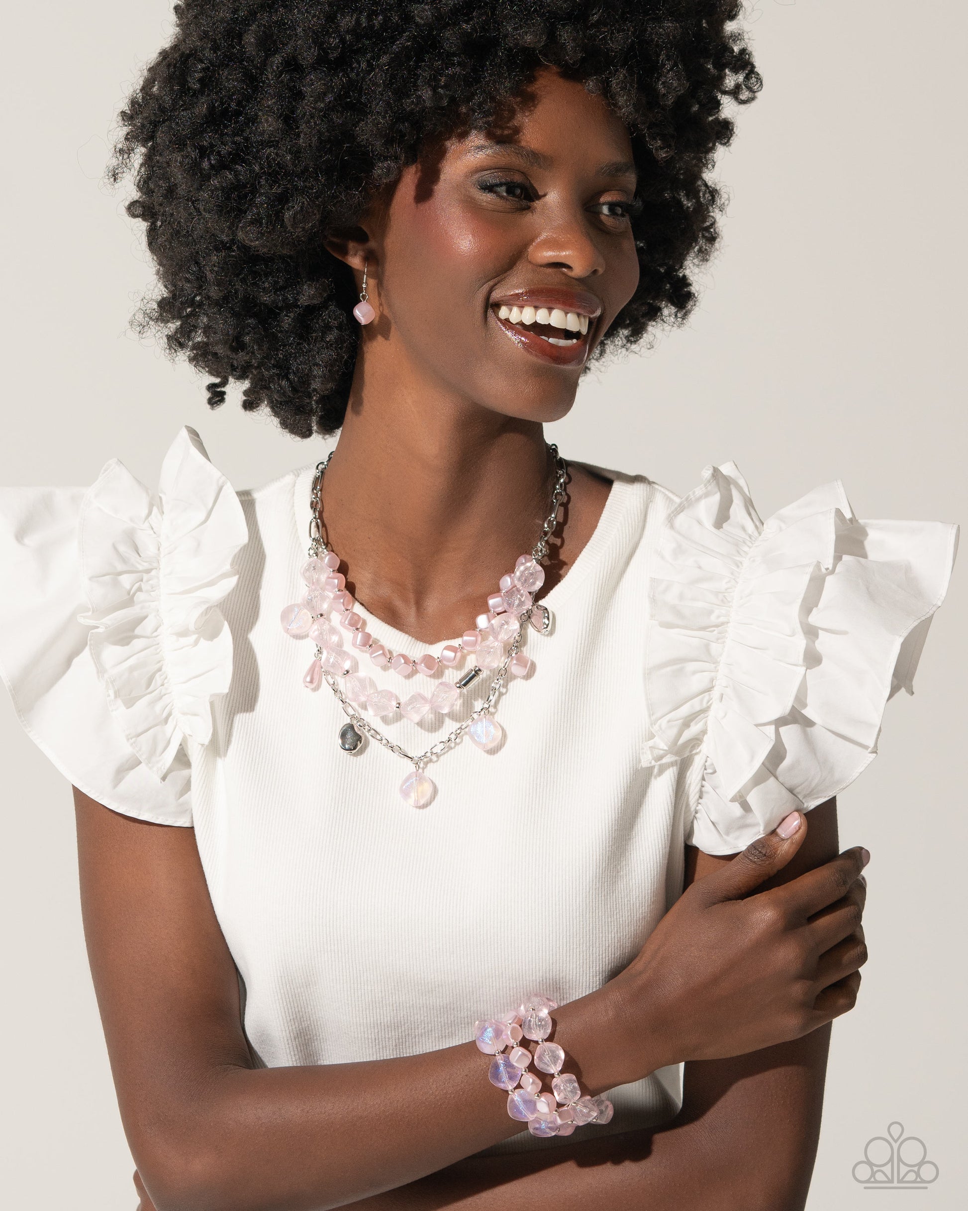 Paparazzi Accessories - Cubed Cameo - Pink Jewelry Sets cubed baby pink pearls join a strand of baby pink clear acrylics that alternate with silver discs and a silver fitting around the neckline. A third strand joins the refined display featuring a silver abstract chain that has dangling silver beads, baby pink pearls in a variety of shapes, and glittery clear acrylics for a classy display. Features an adjustable clasp closure. Sold as one individual necklace. Includes one pair of matching earrings.