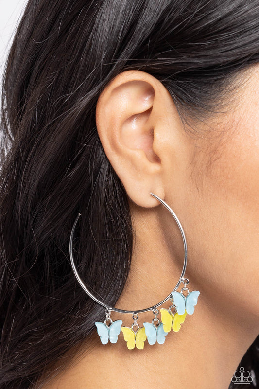 Paparazzi Accessories - Bemusing Butterflies - Blue Earrings attaches along an oversized silver hoop, various blue and yellow butterflies flutter and fly along the ear for a whimsical finish. Earring attaches to a standard post fitting. Hoop measures approximately 2 1/4" in diameter.  Sold as one pair of hoop earrings.