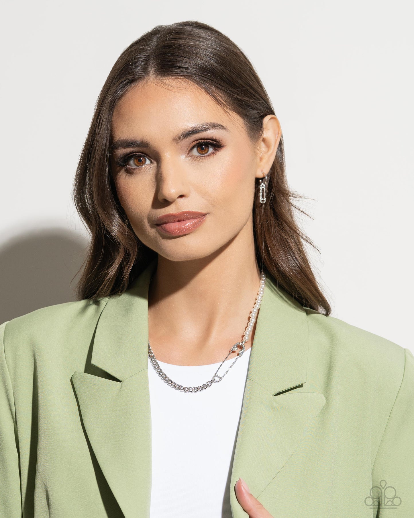 strand of white pearls collides with a layer of chain to create an abstract blend of grit and glitz. The links of the curb chain offset the pearly sheen of the beads that lay on the opposite side, perfectly balancing the contrasting design. A white rhinestone-embellished oversized safety pin charm connects the two strands for a surprising hint of edge. Features an adjustable claspSold as one individual necklace. Includes one pair of matching earrings. Earring: "Safety Pin Sentiment - White"