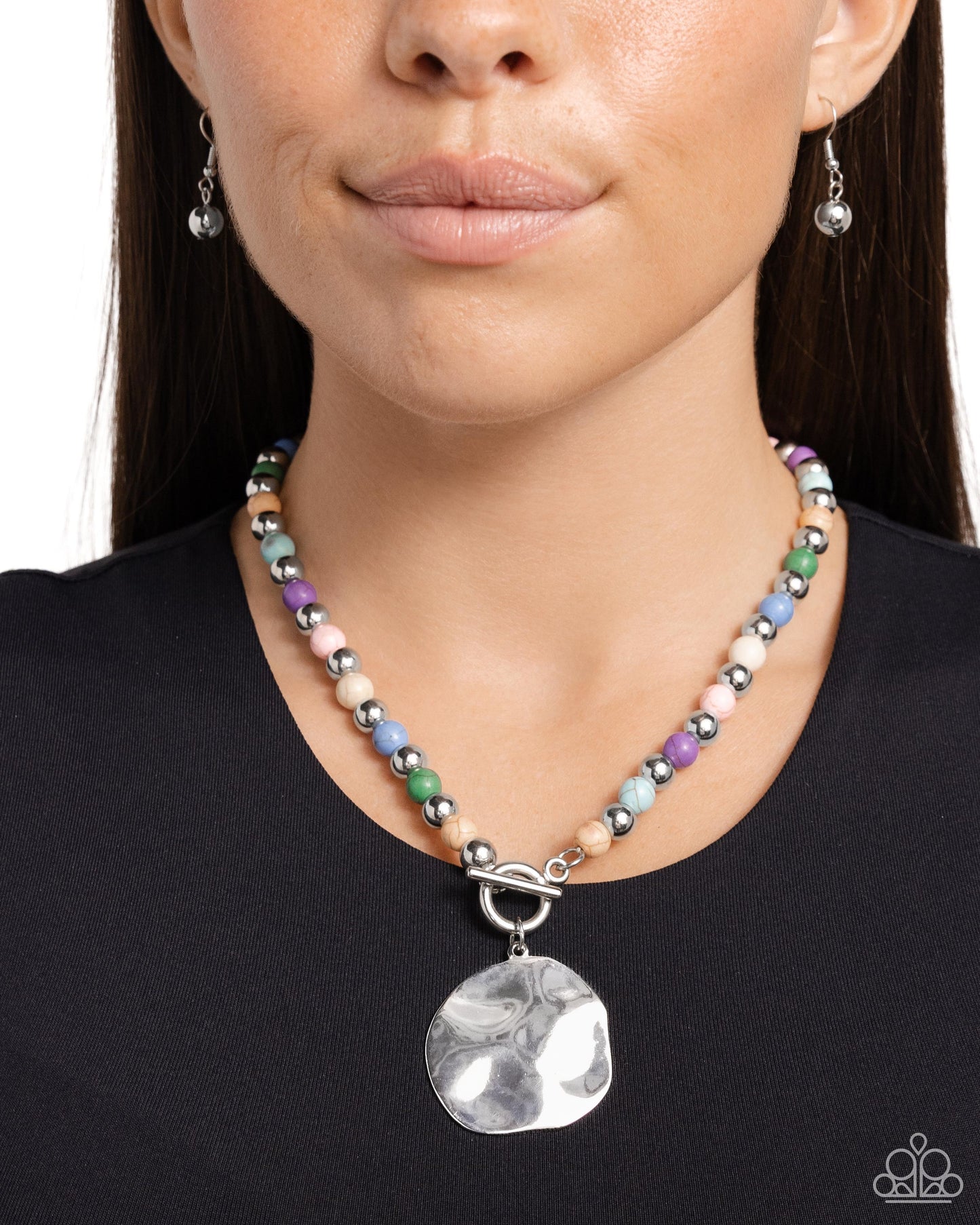 <p data-mce-fragment="1">Infused along an invisible string, colorful stones alternate with high-sheen silver beads as they connect through a toggle closure. A hammered oversized concaved silver disc cascades from the colorful strand for additional eye-catching detail. Features a toggle closure. As the stone elements in this piece are natural, some color variation is normal.</p> <p data-mce-fragment="1"><i data-mce-fragment="1">Sold as one individual necklace. Includes one pair of matching earrings.</i></p>