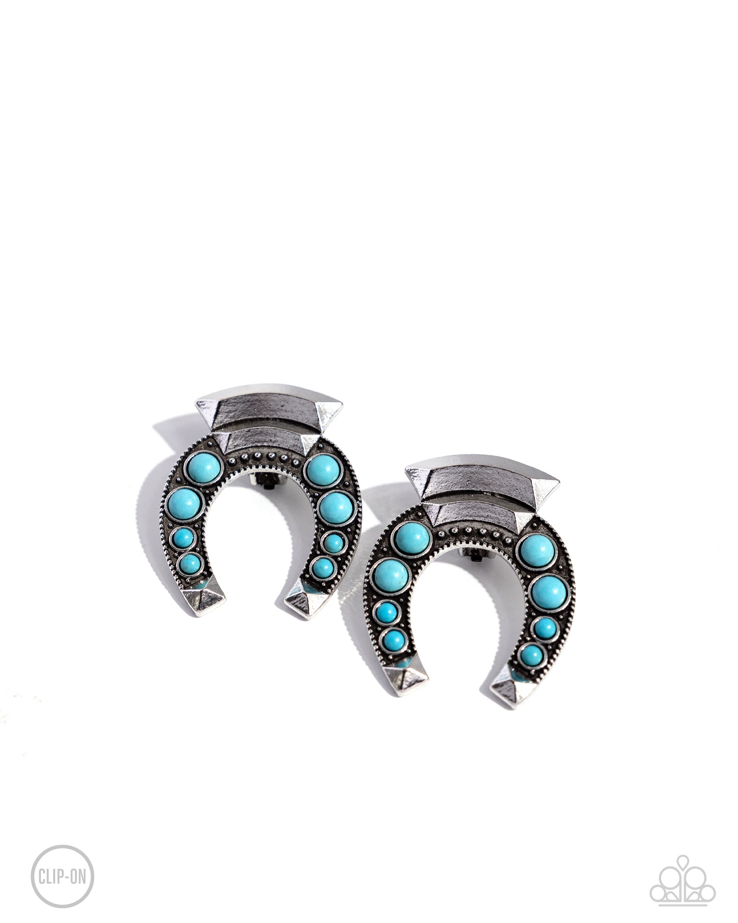 Embellished with turquoise stones and silver-studded details, an oversized antiqued silver horseshoe hangs upside down from a curved high-sheen silver accent. Additional high-sheen textured silver squares that come to a point, cap the ends of the horseshoe for additional eye-catching color. Earring attaches to a standard clip-on fitting. As the stone elements in this piece are natural, some color variation is normal. Sold as one pair of clip-on earrings.
