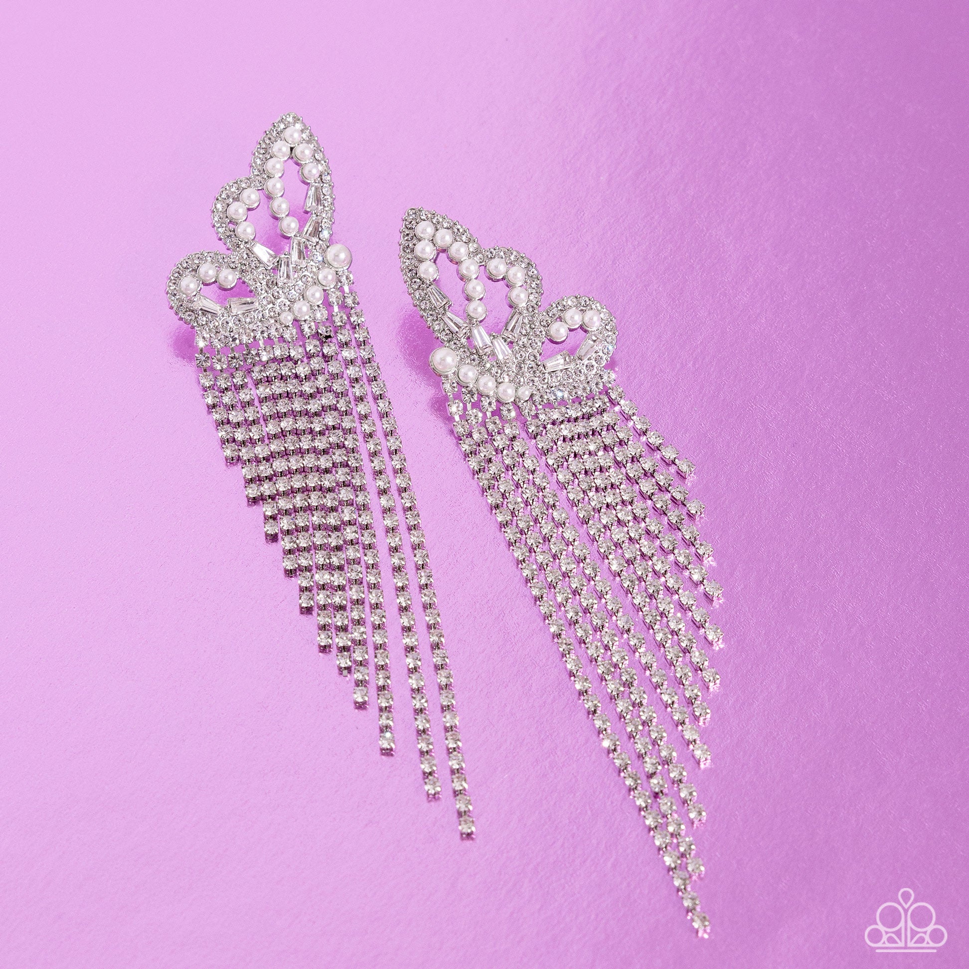 <p>Paparazzi Accessories - Aerial Accent - White Earrings glassy white rhinestones, dainty white pearls, and white emerald-cut gems are encrusted along the front of an airy silver butterfly frame, creating a whimsical centerpiece. Staggered rows of white rhinestones pressed in delicate silver square fittings cascade from the sparkly centerpiece, seemingly lifting the butterfly off to its glitzy flight. Earring attaches to a standard post fitting.</p> <p><i>Sold as one pair of post earrings.</i></p>