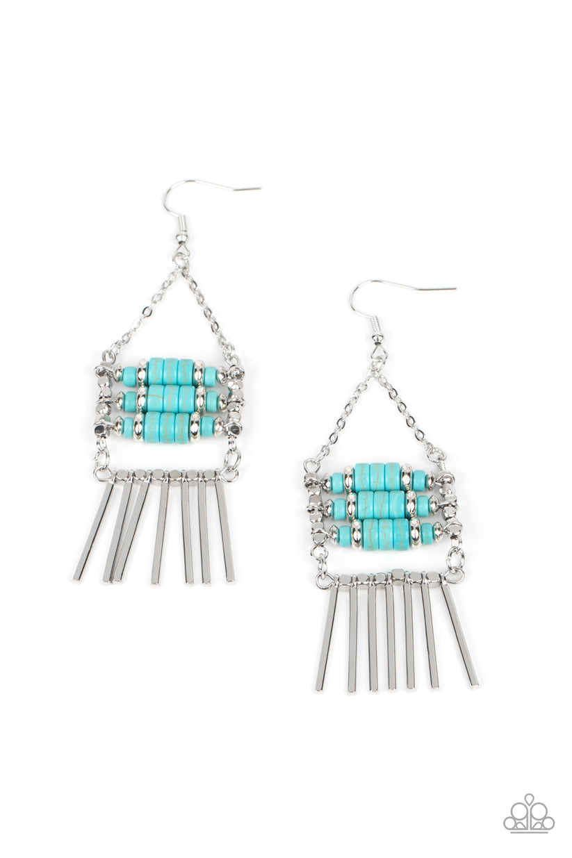 Rows of cylindrical silver and turquoise stone beads are threaded along metal rods between faceted silver cubes. Silver rods stream out from the bottom of the stacked display, resulting in an earthy fringe. Earring attaches to a standard fishhook fitting. Sold as one pair of earrings.