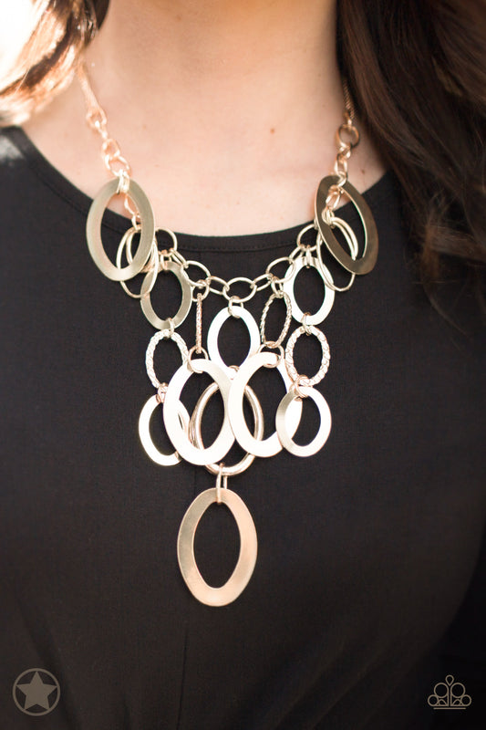 Paparazzi Accessories A Golden Spell - Gold Blockbuster Necklaces large gold links and shimmering textured gold rings cascade below a gold chain freely, allowing for movement that makes a bold statement. Features an adjustable clasp closure.