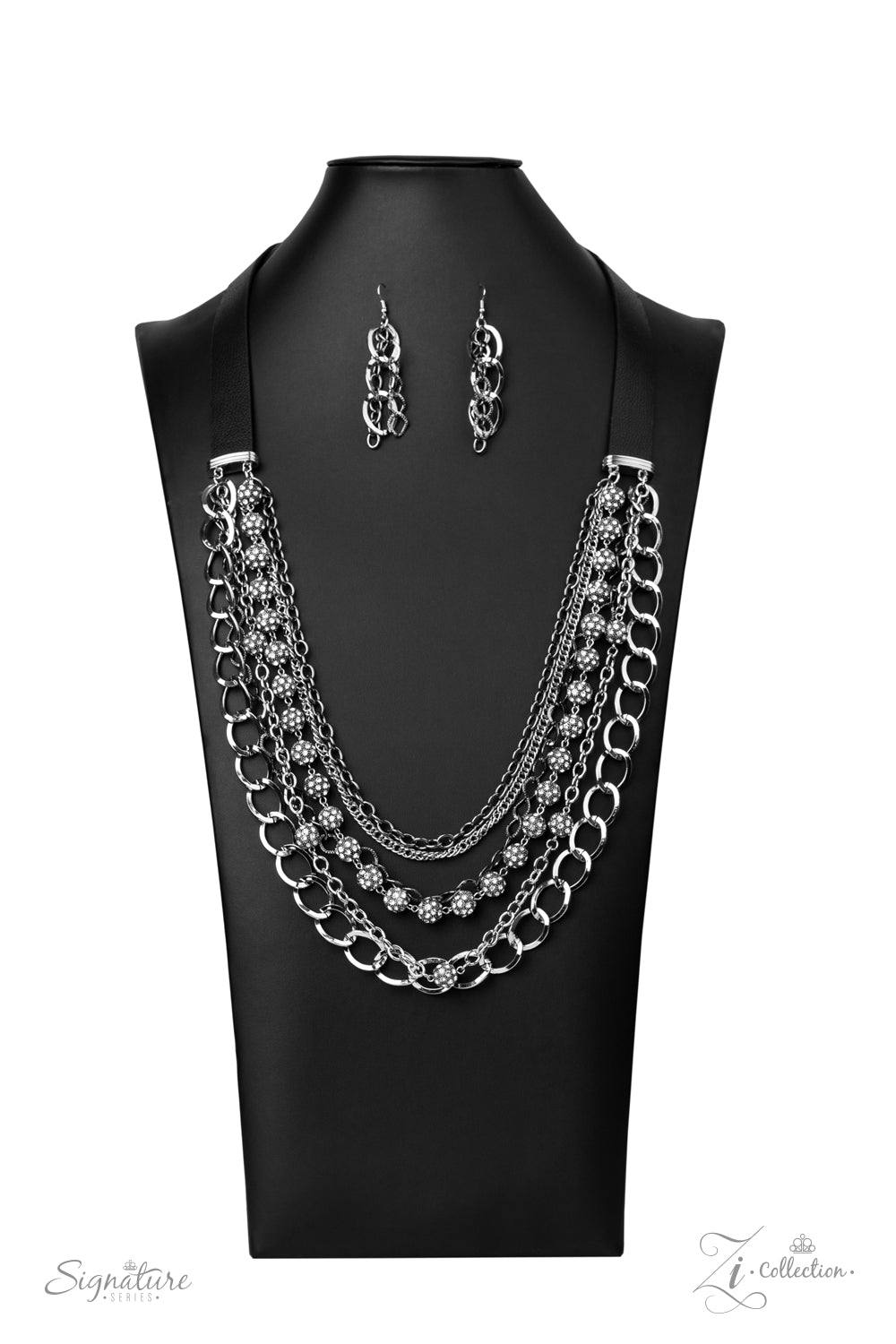 The Arlingto 2020 Zi Collection Necklaces attached to two strips of black leather, strands of bedazzled white rhinestone encrusted silver beads drape between an exaggerated display of mismatched silver and gunmetal chains down the chest. With its edgy sparkle, grunge meets glamour in this heart-stopping statement-maker. Features an adjustable clasp closure. Sold as one individual necklace. Includes one pair of matching earrings.
