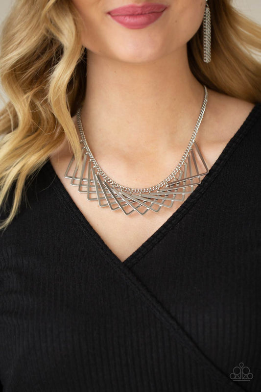 Metro Mirage - Silver Collar Necklaces a shiny collection of silver V-shape frames delicately overlap below the collar, creating an edgy optical illusion. Features an adjustable clasp closure.  Sold as one individual necklace. Includes one pair of matching earrings.  Paparazzi Jewelry is lead and nickel free so it's perfect for sensitive skin too!