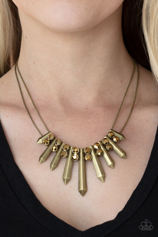 Paparazzi Accessories Dangerous Dazzle - Brass Necklaces Pairs of glittery aurum rhinestones alternate between flared brass rods that are threaded along two rows of flat brass chains, creating a dangerous fringe below the collar. Features an adjustable clasp closure.  Sold as one individual necklace. Includes one pair of matching earrings.  Paparazzi Jewelry is lead and nickel free so it's perfect for sensitive skin too!