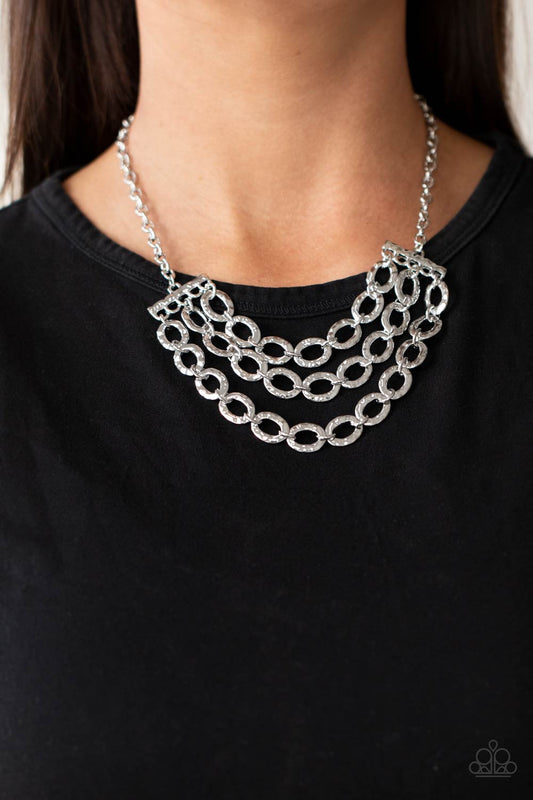 Repeat After Me - Silver Oval Link Necklaces three rows of shiny silver chains with oversized hammered oval links attach to silver bars for an edgy display below the collar. Features an adjustable clasp closure.  Sold as one individual necklace. Includes one pair of matching earrings.  Paparazzi Jewelry is lead and nickel free so it's perfect for sensitive skin too!