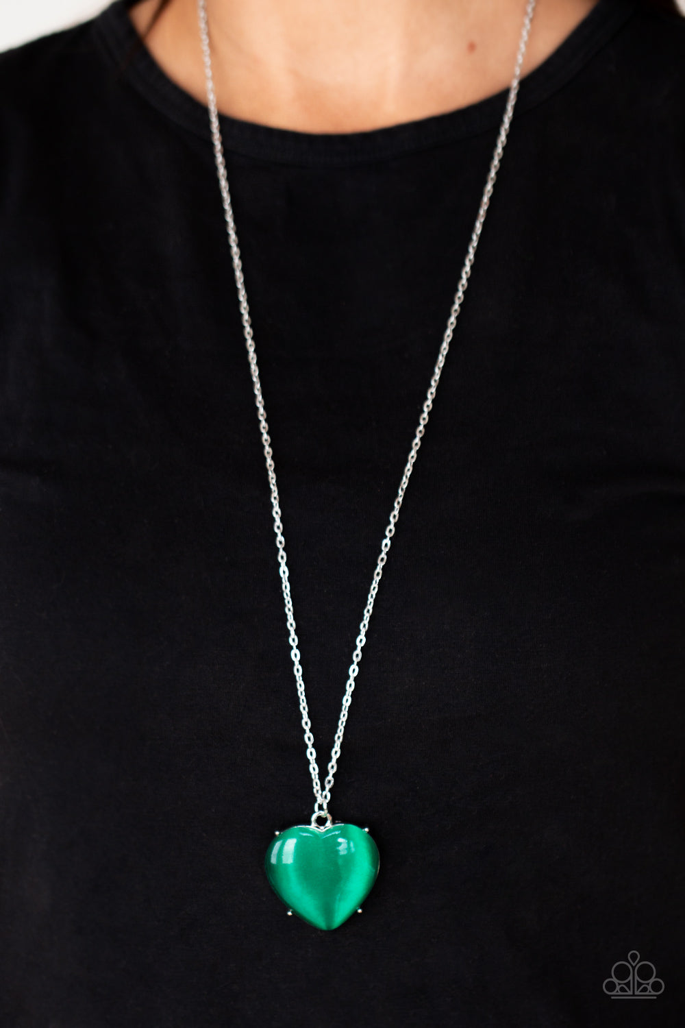 Warmhearted Glow - Green Necklaces oversized Mint cat's eye stone frame swings from the bottom of a lengthened silver chain, creating a flirtatious pendant. Features an adjustable clasp closure.  Sold as one individual necklace. Includes one pair of matching earrings.  Paparazzi Jewelry is lead and nickel free so it's perfect for sensitive skin too!