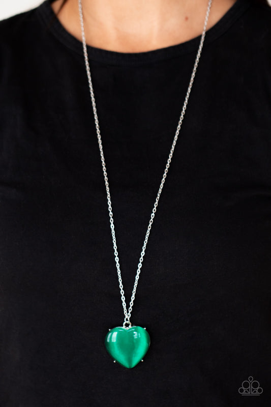 Warmhearted Glow - Green Necklaces oversized Mint cat's eye stone frame swings from the bottom of a lengthened silver chain, creating a flirtatious pendant. Features an adjustable clasp closure.  Sold as one individual necklace. Includes one pair of matching earrings.  Paparazzi Jewelry is lead and nickel free so it's perfect for sensitive skin too!