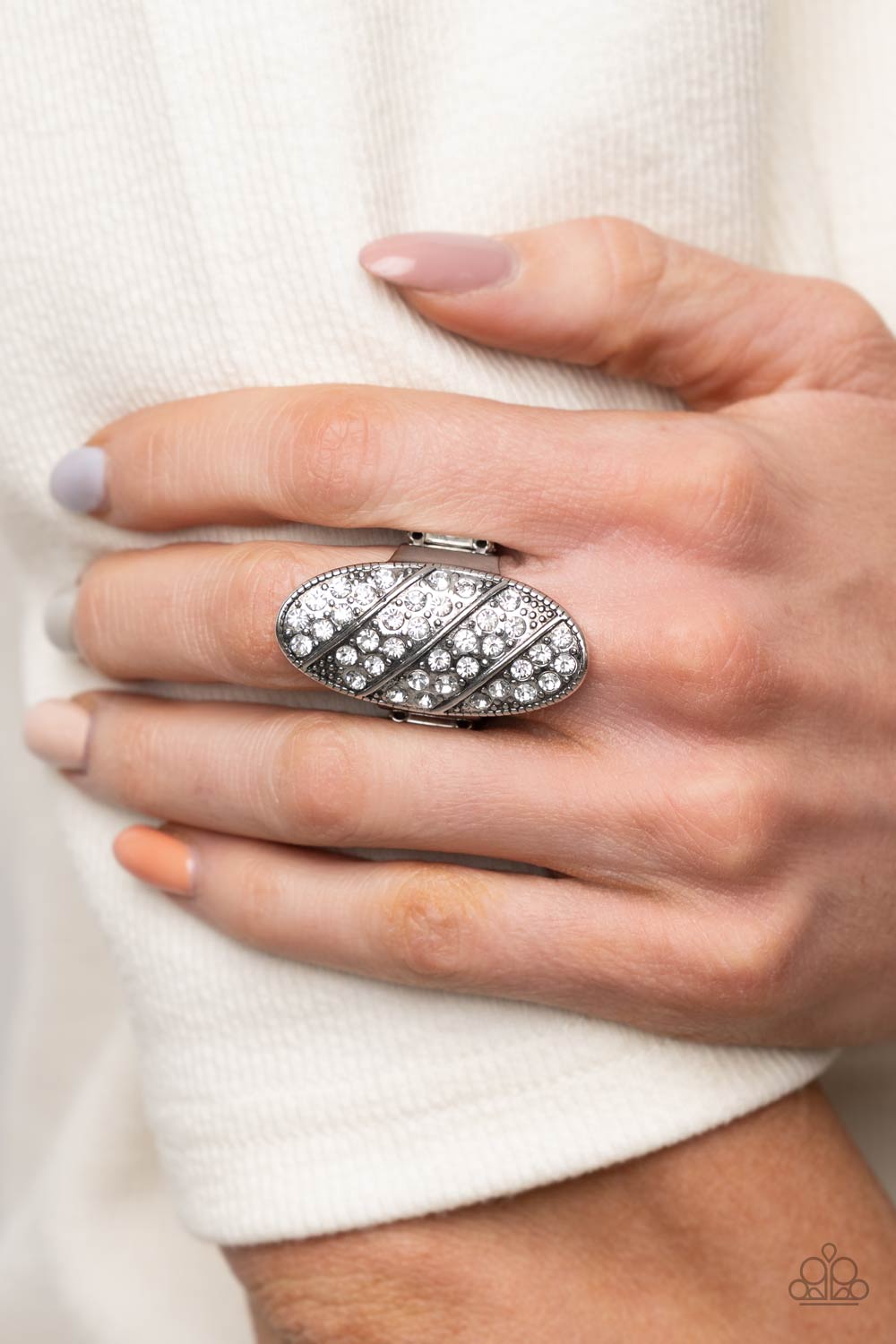 Galactic Glitz - White Ring rows of glassy white rhinestones slant across a stretched oval frame dotted in silver studs, creating a dramatic centerpiece atop the finger. Features a stretchy band for a flexible fit.  Sold as one individual ring.  Paparazzi Jewelry is lead and nickel free so it's perfect for sensitive skin too!