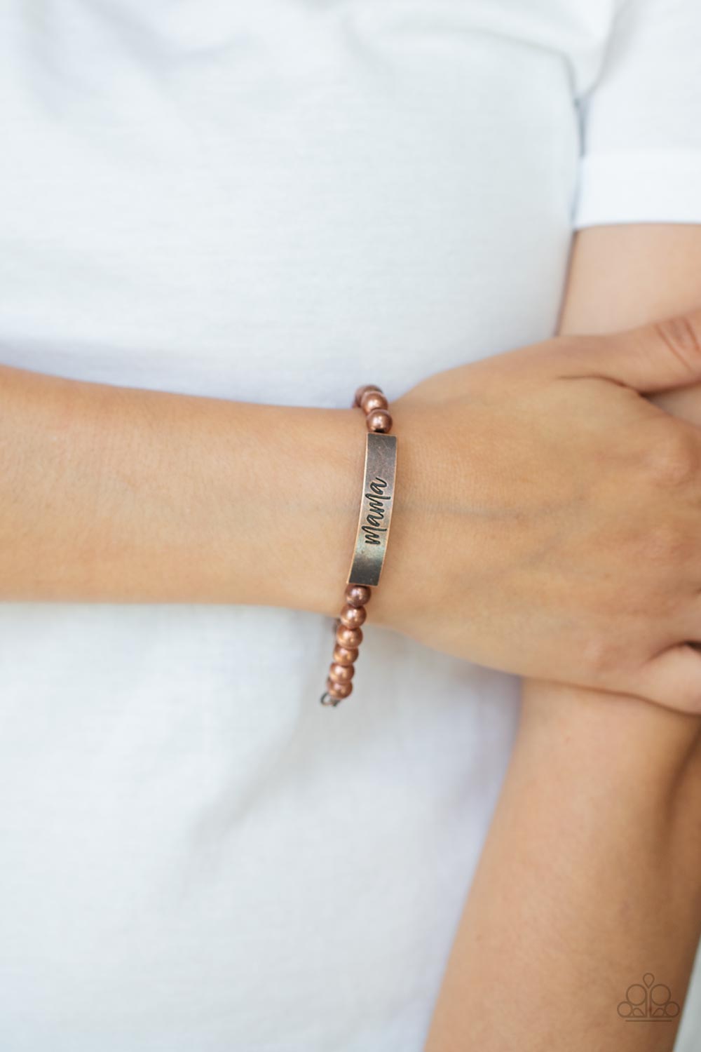 Mom Squad - Copper Bead Bracelets stamped in the word, "Mama," a curved copper plate attaches to strands of copper beads threaded along invisible wire around the wrist, creating a sentimental centerpiece. Features an adjustable clasp closure. Sold as one individual bracelet.