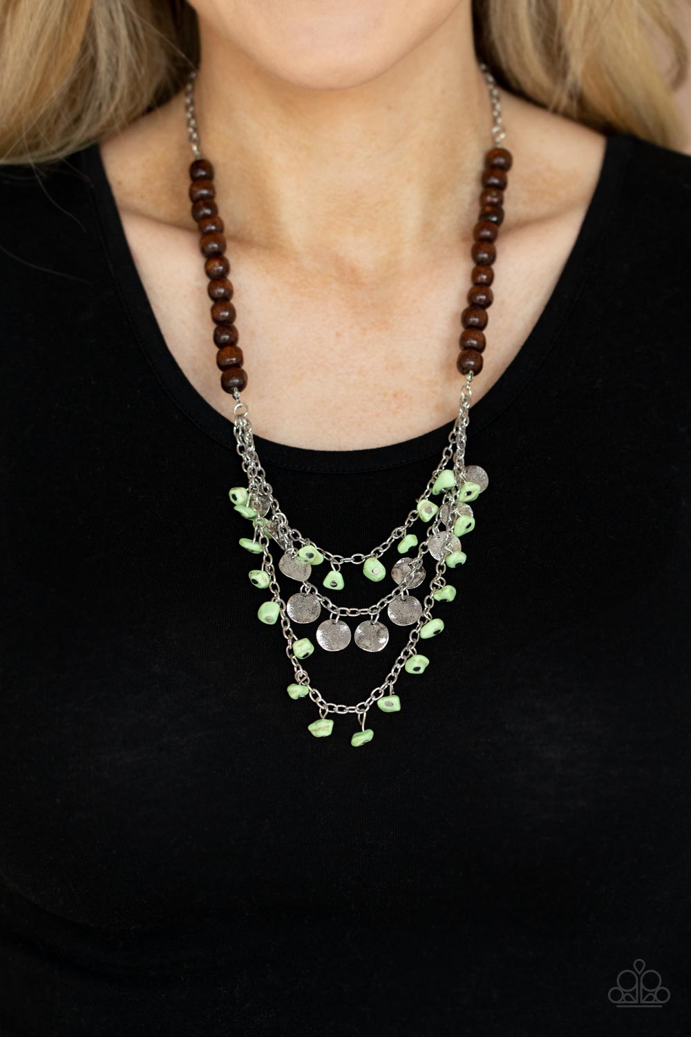 Plains Paradise - Green Wood Necklaces adorned with green pebbles and hammered silver discs, three silver chains layer from strands of brown wooden beads, creating an earthy fringe below the collar. Features an adjustable clasp closure. Sold as one individual necklace. Includes one pair of matching earrings.