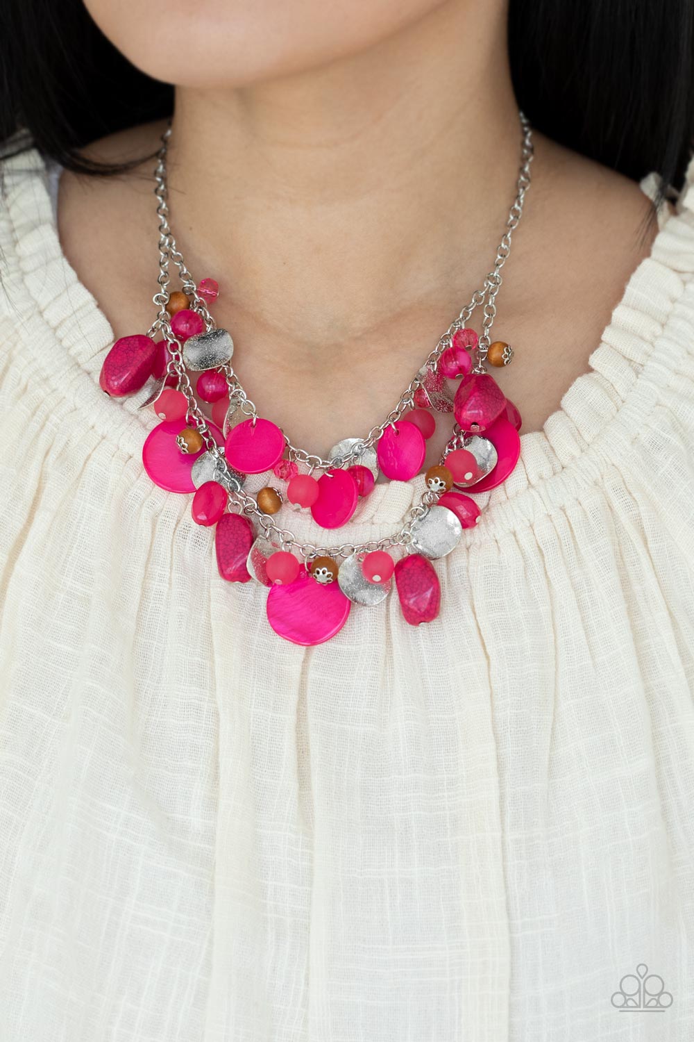 Spring Goddess - Pink Necklaces infused with wooden beads and silver discs, an earthy collection of glassy, opaque, and shell-like Raspberry Sorbet beads swing from two silver chains. The vivacious display effortlessly layers below the collar, creating a springtime inspired fringe. Features an adjustable clasp closure. Sold as one individual necklace. Includes one pair of matching earrings. Get The Complete Look! Bracelet: "Springtime Springs - Pink" (Sold Separately)