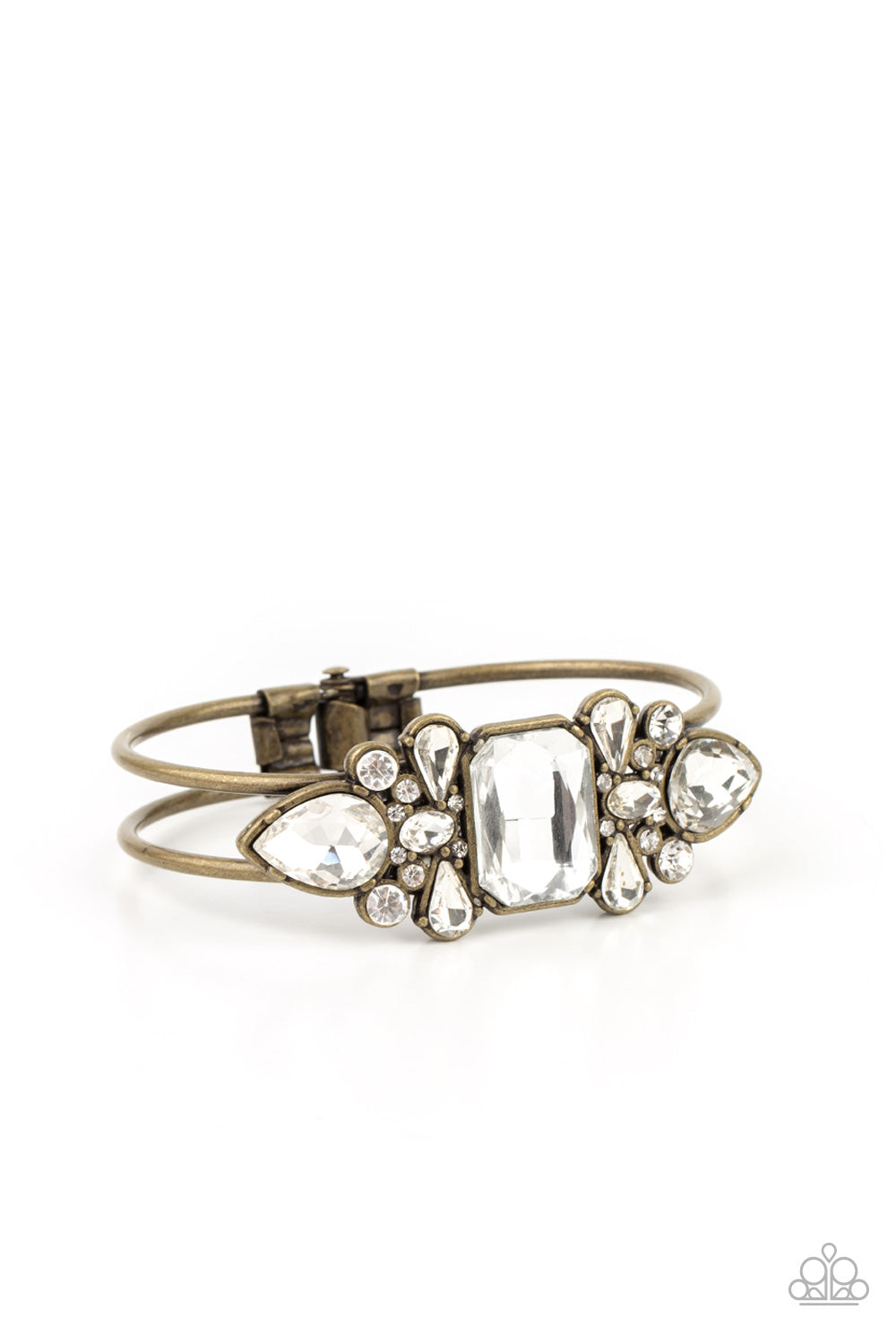 Call Me Old-Fashioned - Brass Hinge Rhinestone Bracelet featuring regal teardrop, oval, emerald, and round cuts, an explosion of oversized rhinestones neatly coalesce into a sparkly centerpiece atop an antiqued brass cuff for a dramatically dazzling display. Features a hinged closure. Sold as one individual bracelet. Paparazzi Jewelry is lead and nickel free so it's perfect for sensitive skin too!