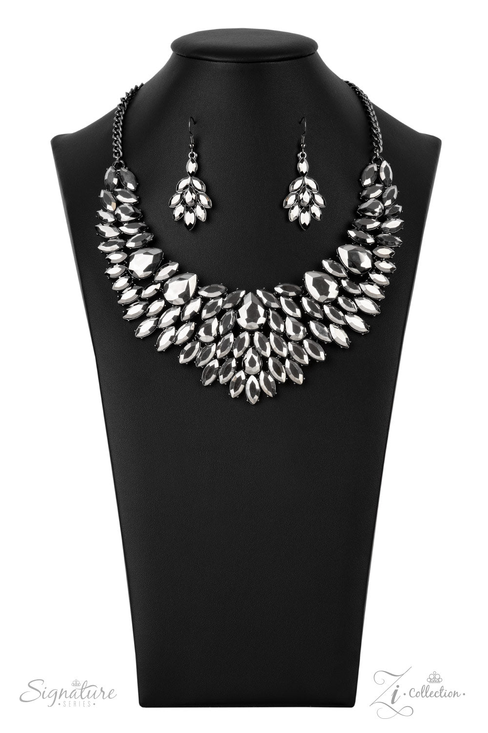 The Tanisha - 2021 Zi Collection Necklace smoldering collection of oversized teardrop and marquise cut hematite rhinestones daringly fan out from the collar, coalescing into intense interconnected frames. The dauntless display of dazzle locks in place, creating a stunningly solitaire sparkle. Features an adjustable clasp closure.  Named after the 2021 Seize the Spotlight winner, Tanisha F.  Sold as one individual necklace. Includes one pair of matching earrings.