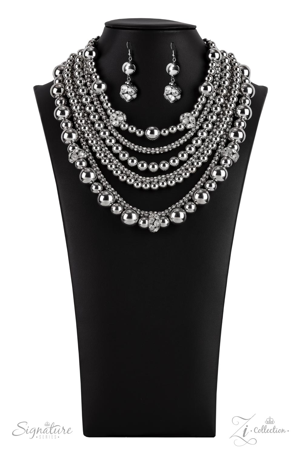 The Liberty - 2021 Zi Collection Necklace held together by rectangular silver frames, a couture-clutching collection of oversized silver beads interspersed with white rhinestone encrusted ornaments alternates with interlocking rows of white rhinestone encrusted chains across the chest. Edgily enhanced with linked rows of silver chain fittings, the emboldened silver layers demand to be seen with their unapologetic attitude. Features an adjustable clasp closure.