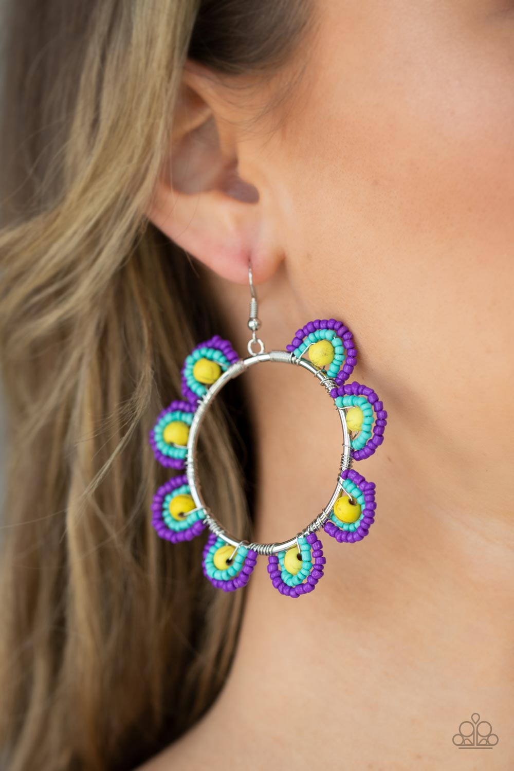 Paparazzi Groovy Gardens - Yellow Seedbead Earrings infused with sunny yellow stone bead centers, rows of purple and turquoise seed beads are threaded along dainty wires along the outside of a shiny silver hoop for a vivacious floral look. Earring attaches to a standard fishhook fitting.  Sold as one pair of earrings.