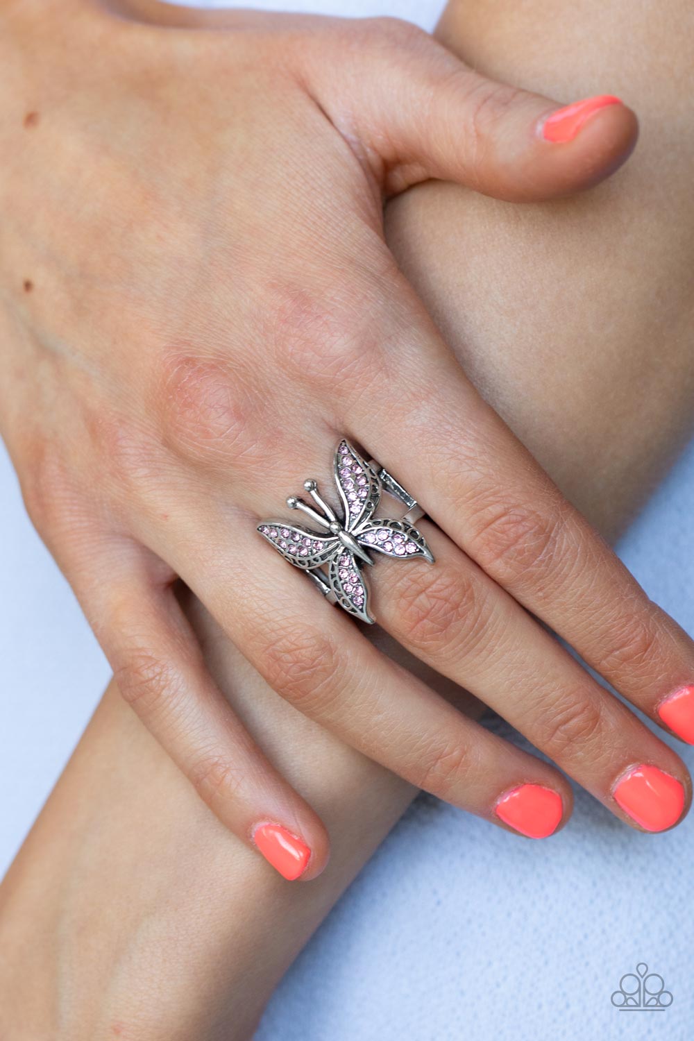 Blinged Out Butterfly - Pink Rhinestone Rings glittery sections of pink rhinestones delicately encrust the decorative wings of a silver butterfly, creating a whimsically fluttering centerpiece atop the finger. Features a stretchy band for a flexible fit.  Sold as one individual ring.