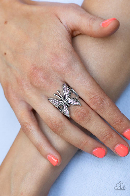 Blinged Out Butterfly - Pink Rhinestone Rings glittery sections of pink rhinestones delicately encrust the decorative wings of a silver butterfly, creating a whimsically fluttering centerpiece atop the finger. Features a stretchy band for a flexible fit.  Sold as one individual ring.