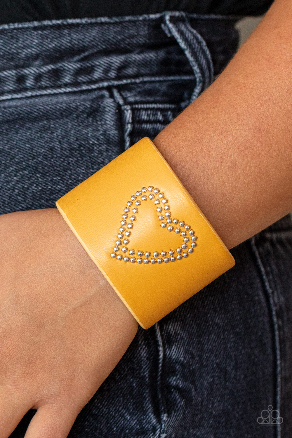 Rodeo Romance - Yellow Leather Heart Cuff Bracelets the center of a yellow leather cuff is studded in a charming heart pattern, creating a rustically romantic look around the wrist. Sold as one individual bracelet.