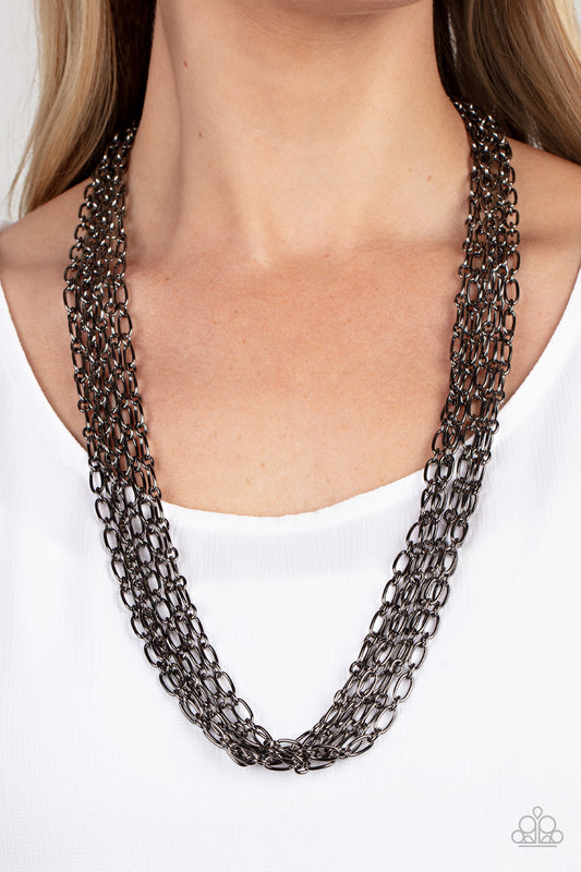 Paparazzi Accessories - Dynamite Dynamo - Black Chain Necklaces layer after layer of edgy gunmetal chains drape across the chest, creating an intense industrial display. Features an adjustable clasp closure.  Sold as one individual necklace. Includes one pair of matching earrings.