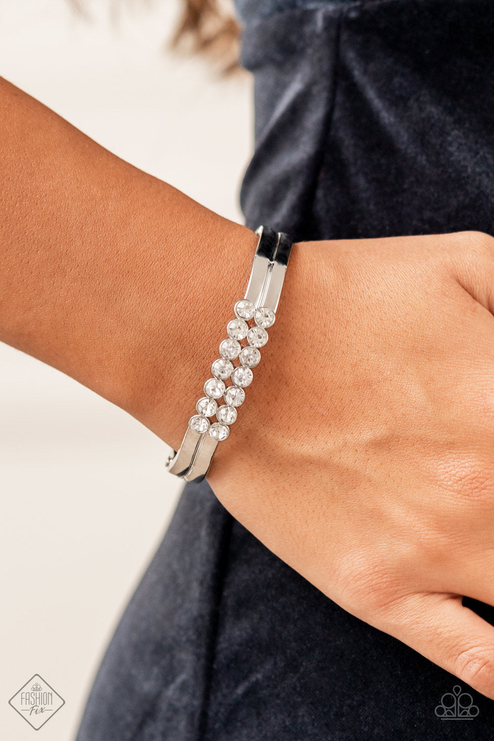 Doubled Down Dazzle - White Rhinestone Bracelets tacked layers of brilliant white rhinestones give way to double layers of sleek silver frames that feature a subtle wave, creating a dramatically modern design around the wrist. Features a hinged closure. Sold as one individual bracelet.