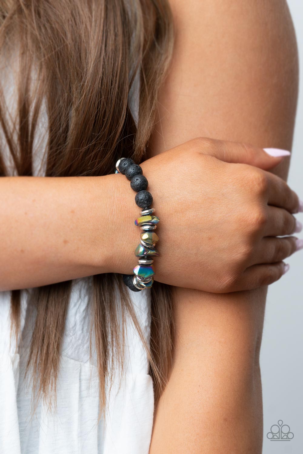 Volcanic Vacay - Multi Lava Bead Bracelets an earthy collection of black lava rock beads, dainty silver discs, and oil spill metallic pebbles are threaded along a stretchy band around the wrist, resulting in an edgy look. Sold as one individual bracelet.
