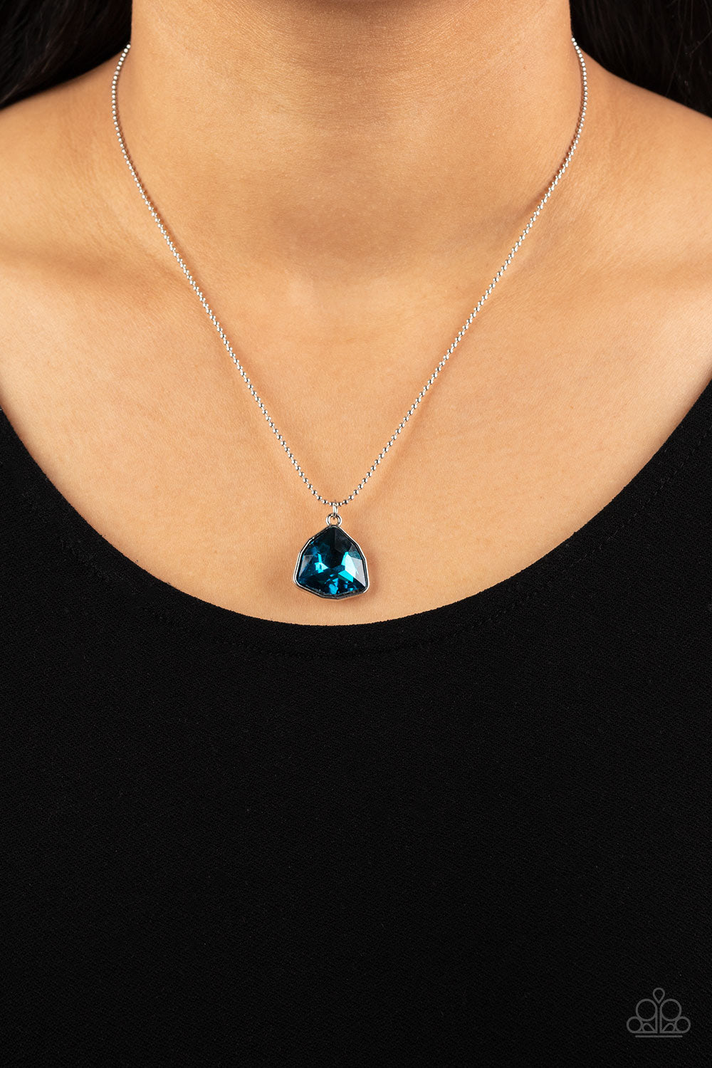 Galactic Duchess - Blue Rhinestone Necklaces faceted asymmetrical blue gem is encased in a sleek silver frame at the bottom of a silver popcorn chain, creating a stellar pendant below the collar. Features an adjustable clasp closure.  Sold as one individual necklace. Includes one pair of matching earrings.