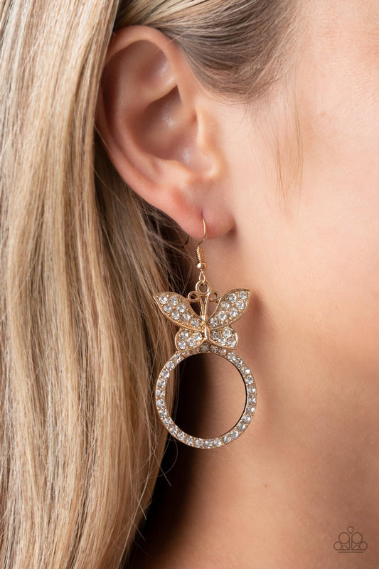 Paradise Found - Gold Rhinestone Butterfly Earrings a white rhinestone encrusted gold butterfly flutters atop a gold ring dotted in matching white rhinestones, resulting in a dazzling statement piece. Earring attaches to a standard fishhook fitting.  Sold as one pair of earrings.