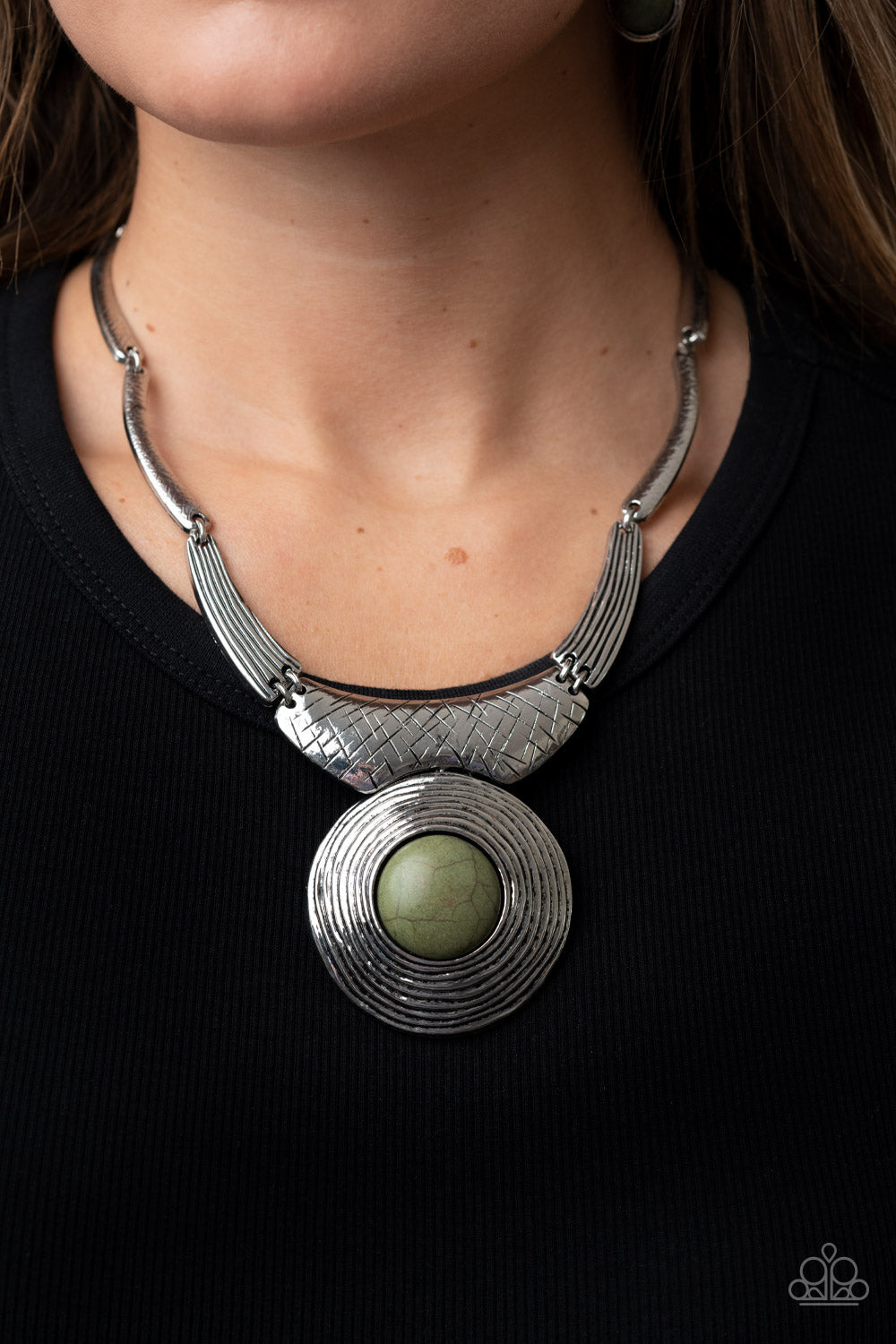 Paparazzi Accessories EMPRESS-ive Resume - Green Necklaces featuring hammered, scratched, and linear patterns, an antiqued assortment of gently curving silver frames boldly links below the collar. Dotted with an oversized Olive Branch stone center, a rustic silver frame radiating with circular texture swings from the bottom for a dramatically earthy flair. Features an adjustable clasp closure. Sold as one individual necklace. Includes one pair of matching earrings.