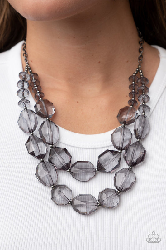 Paparazzi Icy Illumination - Black Faceted Necklaces separated by dainty silver beads, an icy collection of oversized and faceted smoky gems are threaded along invisible wires below the collar, resulting in prismatic layers. Features an adjustable clasp closure.  Sold as one individual necklace. Includes one pair of matching earrings.