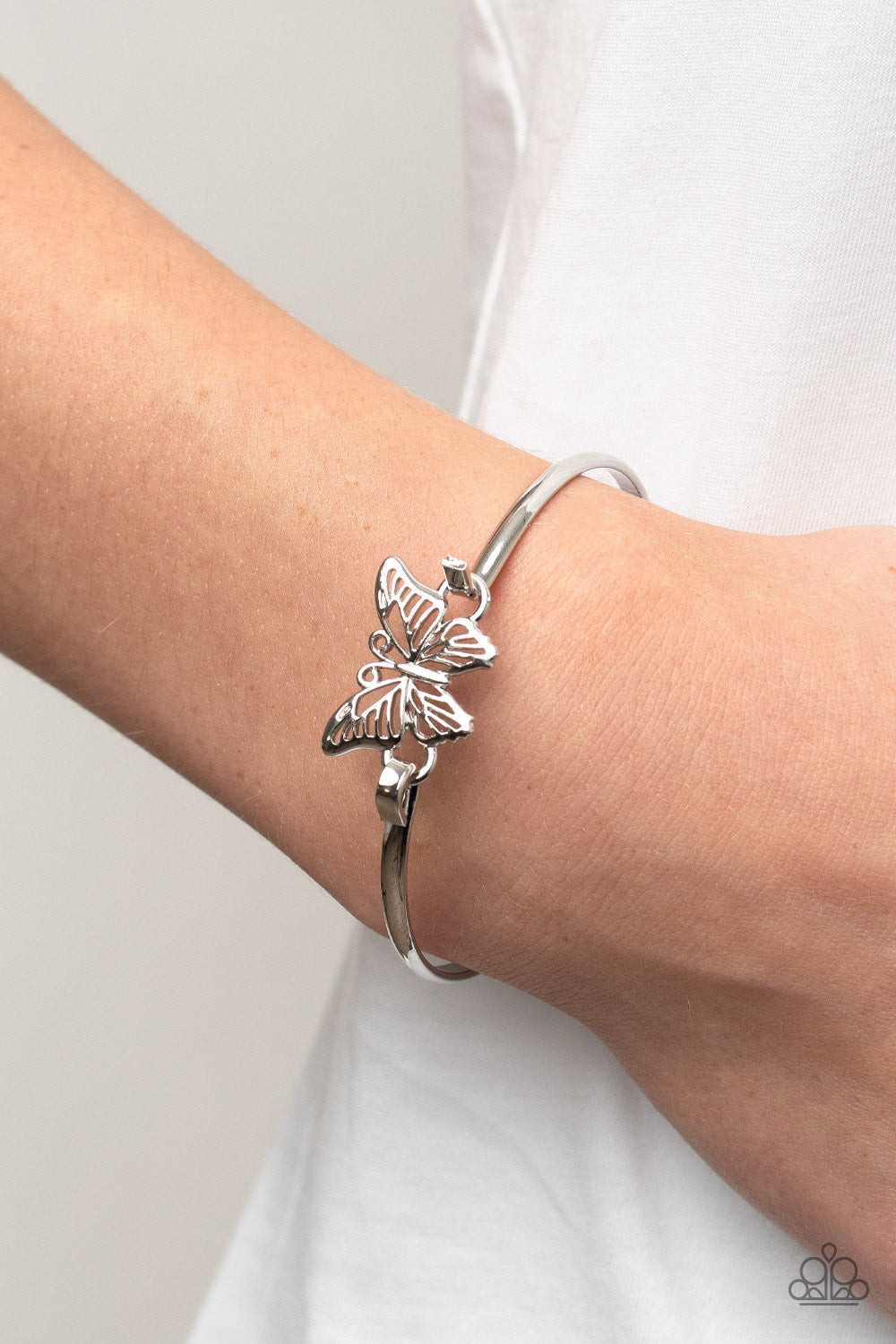 Did I Flutter? - Silver Butterfly Bangle Bracelets attached to a shiny silver bangle-like bracelet, a silver butterfly flutters atop the wrist for a dainty fashion. Features a hook and eye closure. Sold as one individual bracelet.